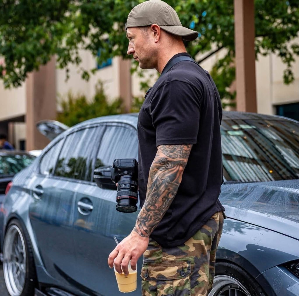 Kayle Barthi, the photographer behind Stay True Photo, holding a camera at a car show